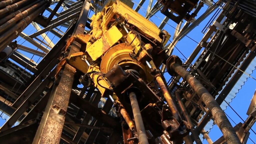 Detailed image of a used top drive system mounted on a drilling rig, showcasing its durable construction and readiness for cost-effective drilling operations.